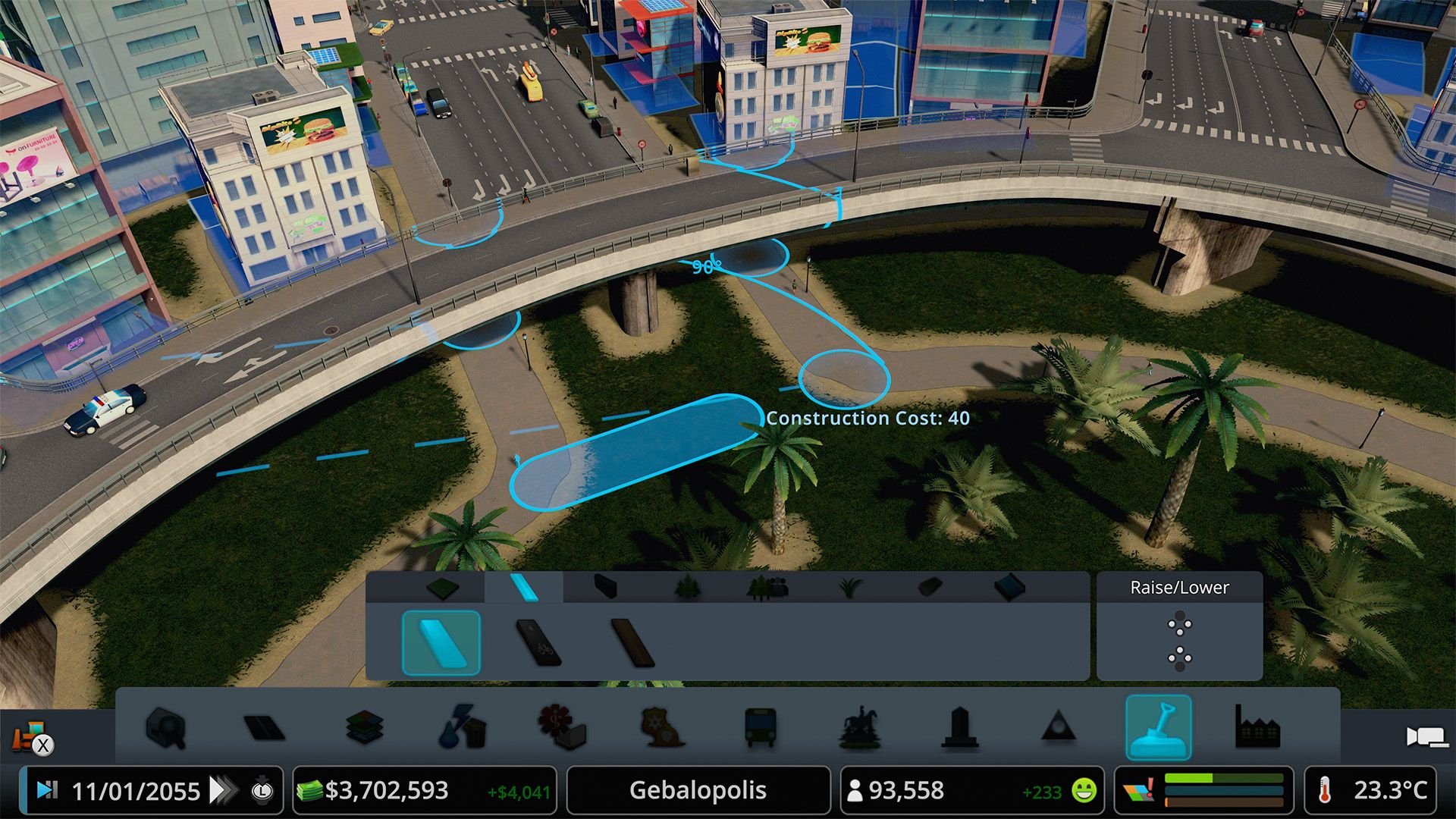A view of an overpass that abuts a green park area with palm trees.