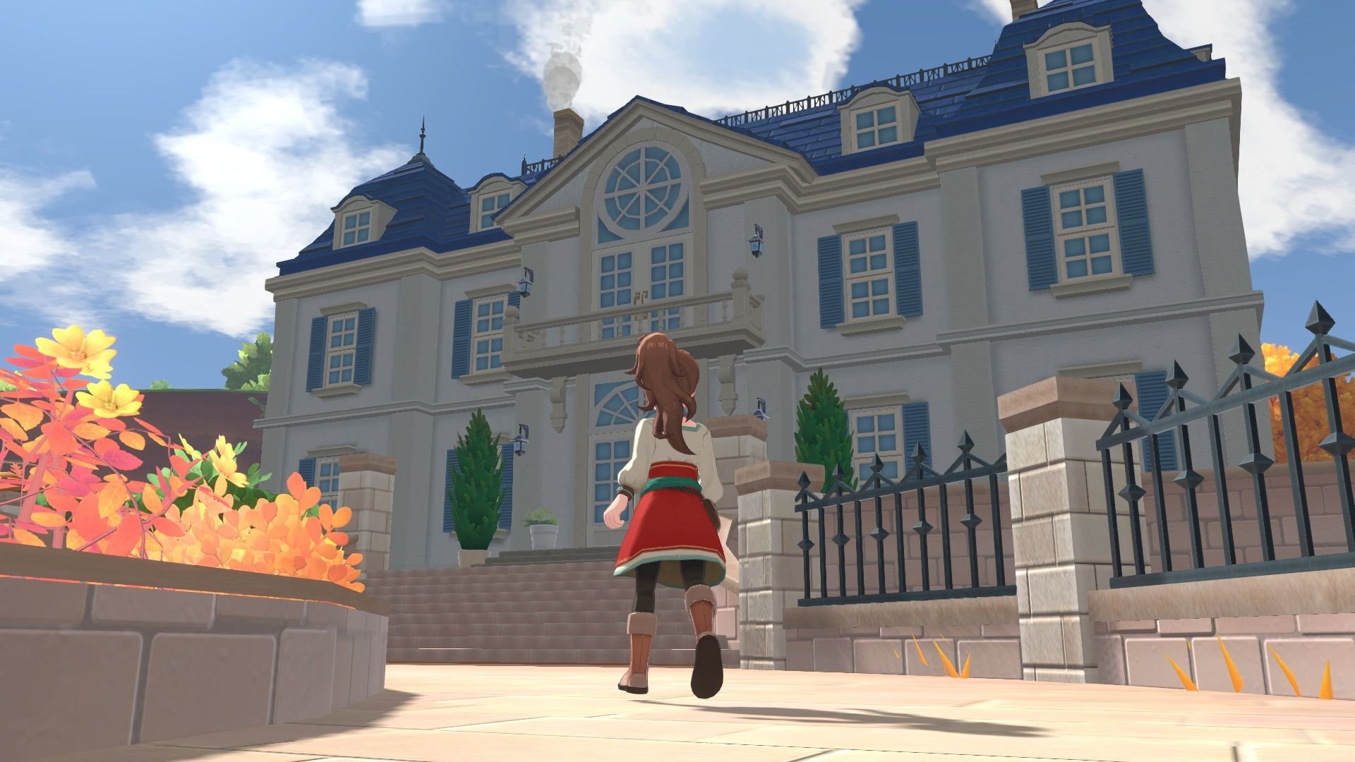 The player character wanders a street, near a fence, as she looks up toward a multi-level mansion framed against a blue sky with clouds.