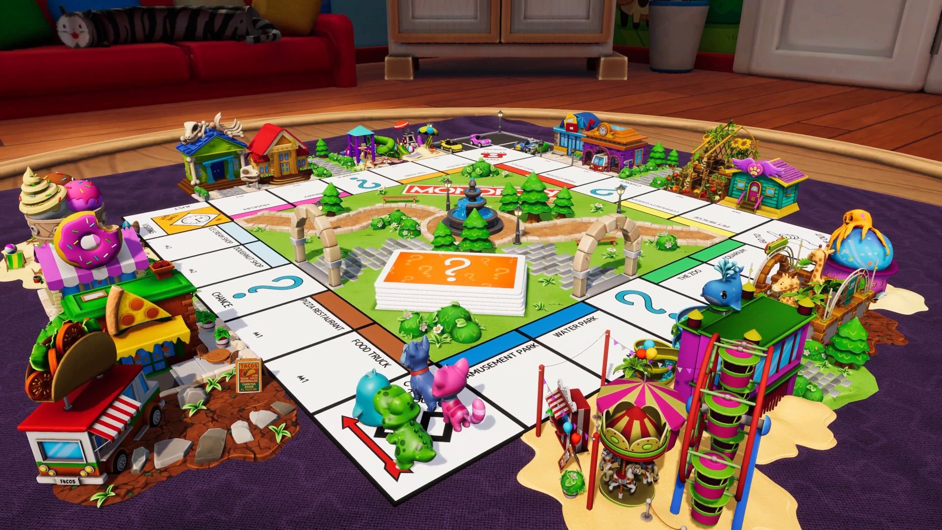 The mascots stand on the Go space along one corner of the Monopoly Jurnior board, with attractions built near the spaces to either side.