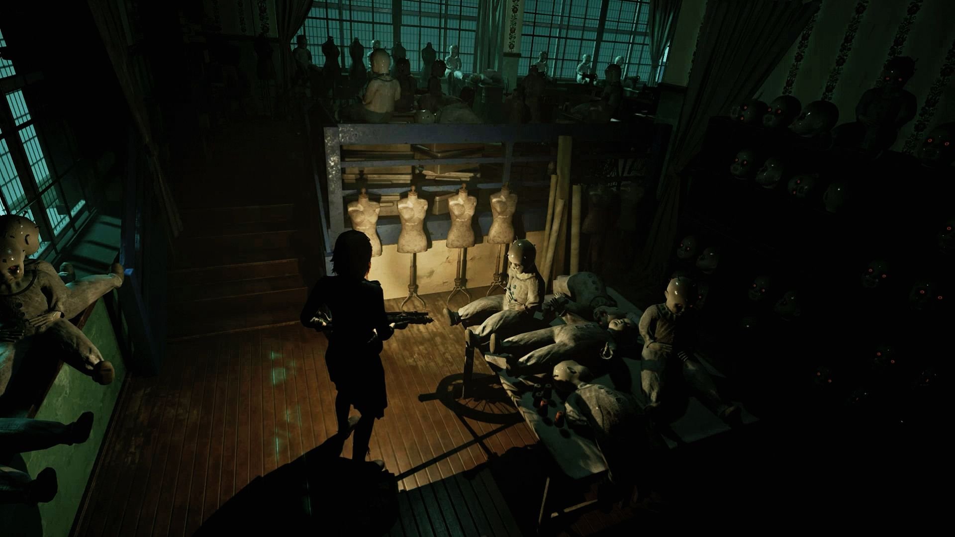 Caroline advances through a workshop shrouded in darkness, while light plays over disassembled dolls on a creaky table.
