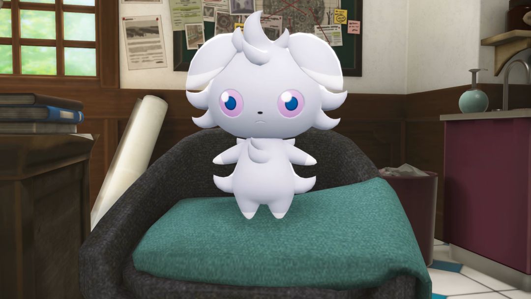 Mimi sits on a green blanket that is draped over the arm of a gray armchair in Emma's detective agency.