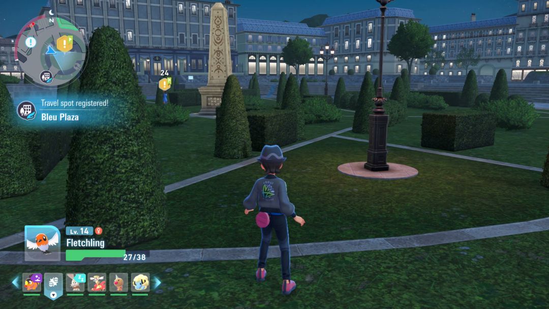 The Pokemon Trainer heads through the Bleu Plaza park, with neatly trimmed bushes ahead of them and to either side.